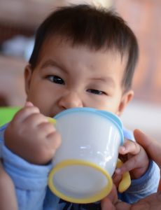 Baby drinking water from cup, South East Asian Thai baby boy