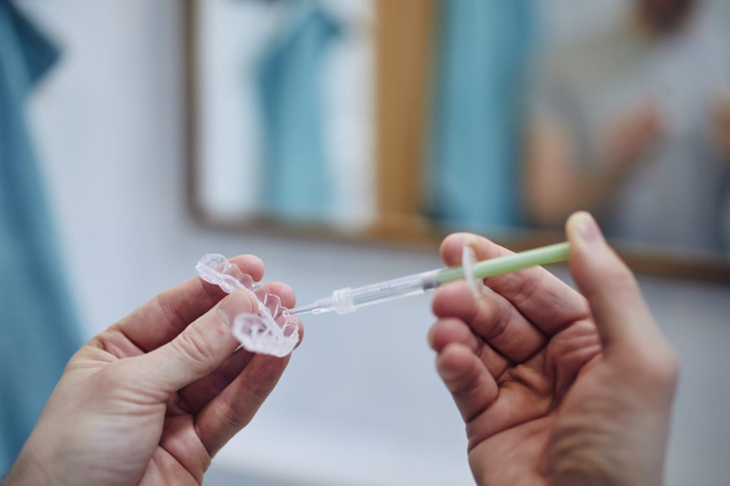 man preparing silicon tray for teeth whitening