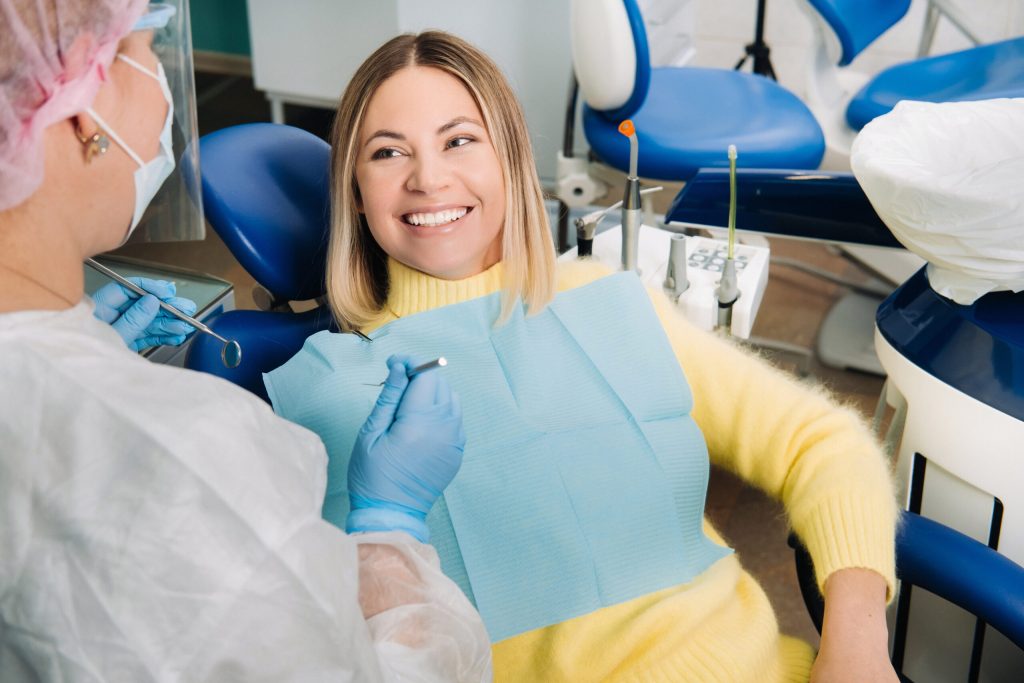 woman sitting in dental chair smiling at her orthodontist