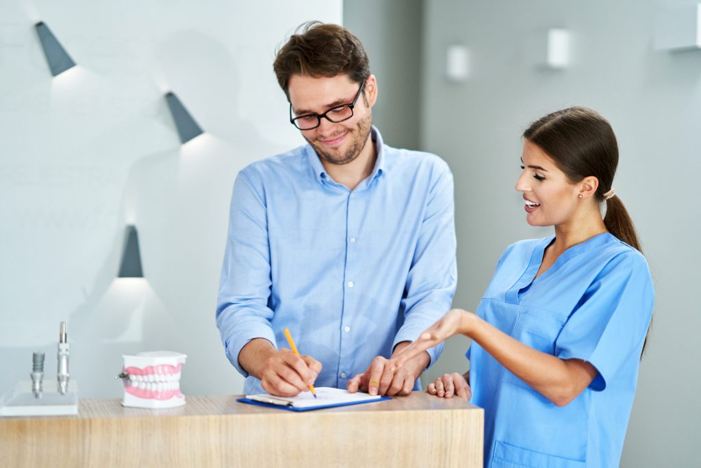 patient signing socuments in dental clinic